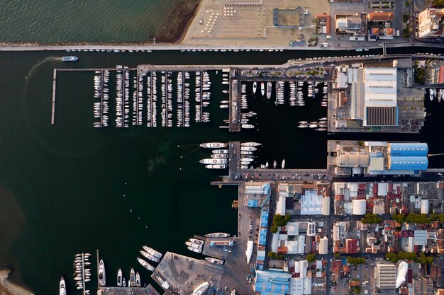 Aerial view of a major port with an unusual number of ships waiting offshore, indicating congestion.