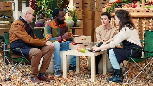 A group of neighbors gathered outdoors, sharing resources and conversation, indicating community resilience and mutual aid during a shared hardship.