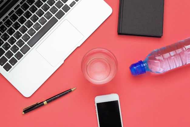 A vibrant fruit-infused water bottle on a desk next to a laptop, suggesting a healthy and productive workspace.