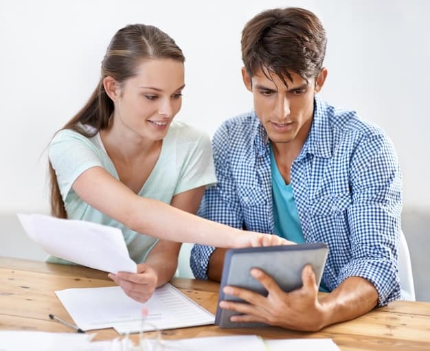 A financial advisor explaining college savings options to a couple, showing different investment charts on a tablet.