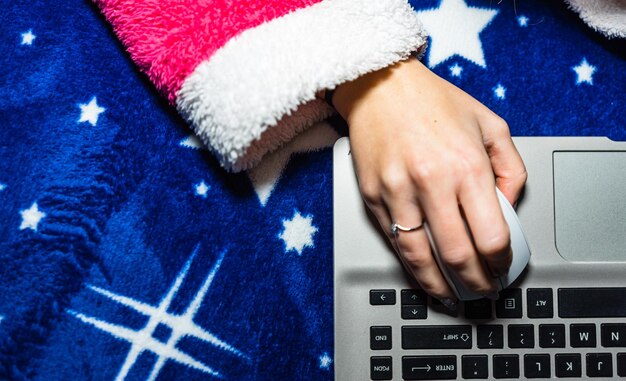 A close-up shot of a user's hands typing on a laptop keyboard, with a state unemployment benefits website clearly visible on the screen. The background is slightly blurred, suggesting a home office environment, emphasizing digital application.